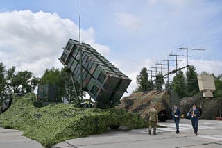Ukrainian servicemen walk past a Patriot air defence system at an undisclosed area in 2024